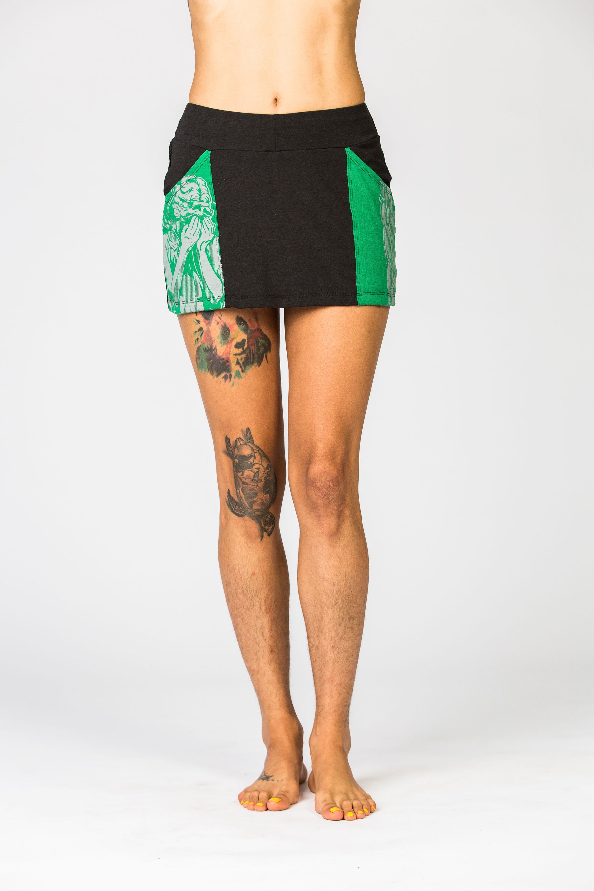 Model is wearing a black mini skirt with green pockets. 